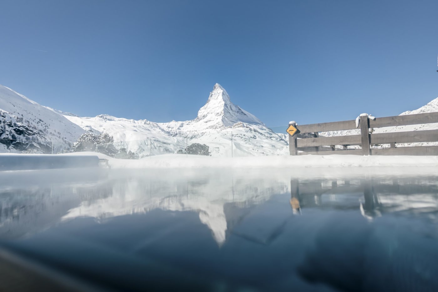 Der beheizte Außenpool des Riffelalp Resort 2222m dampft in der Kälte, vor dem verschneiten Matterhorn