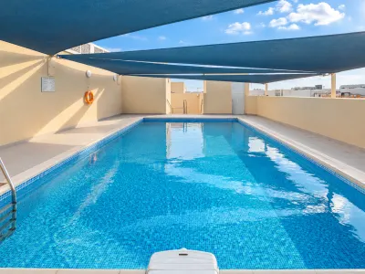 Sunny Rooftop Pool with Blue Shade Sails