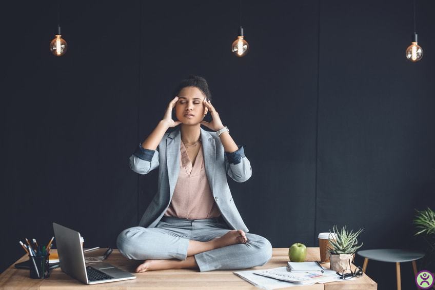 Software developer trying to meditate and be at peace on her desk