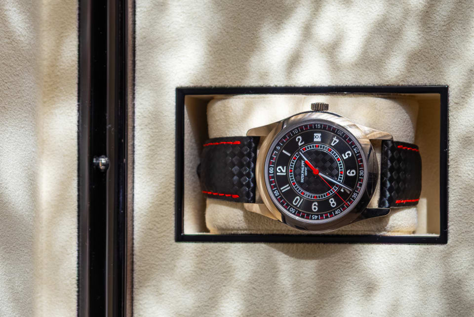 Wide product photo of a watch and fragrance set