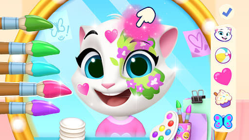 My Talking Tom Friends 2 26.5.0.25768 – melukis wajah Angela di cermin bundar dengan hati dan bunga merah muda, deretan kuas warna-warni di kiri dan pilihan stempel di kanan