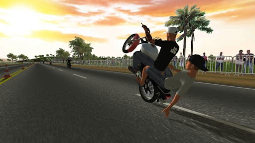 Moto Wheelie 3D 0.122 – stunt saat matahari terbenam di lintasan berkerucut, rider menahan standing di footstep sementara penumpang bertopi terjatuh dari boncengan di depan penonton