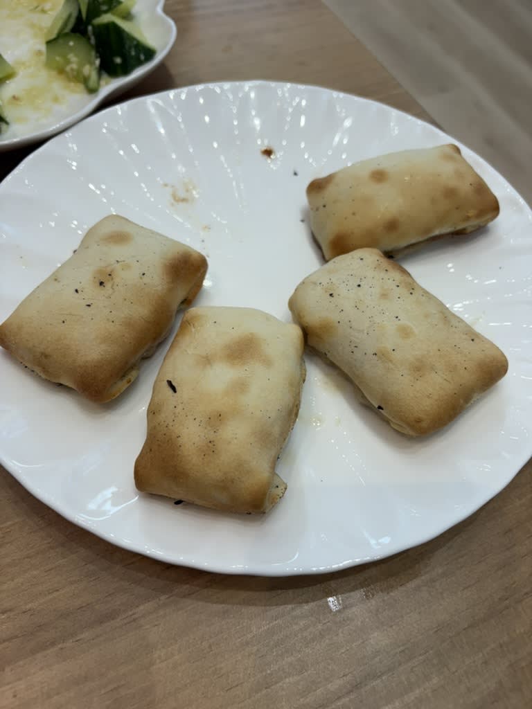 Four golden rectangular Urumqi baked buns arranged on a white plate.