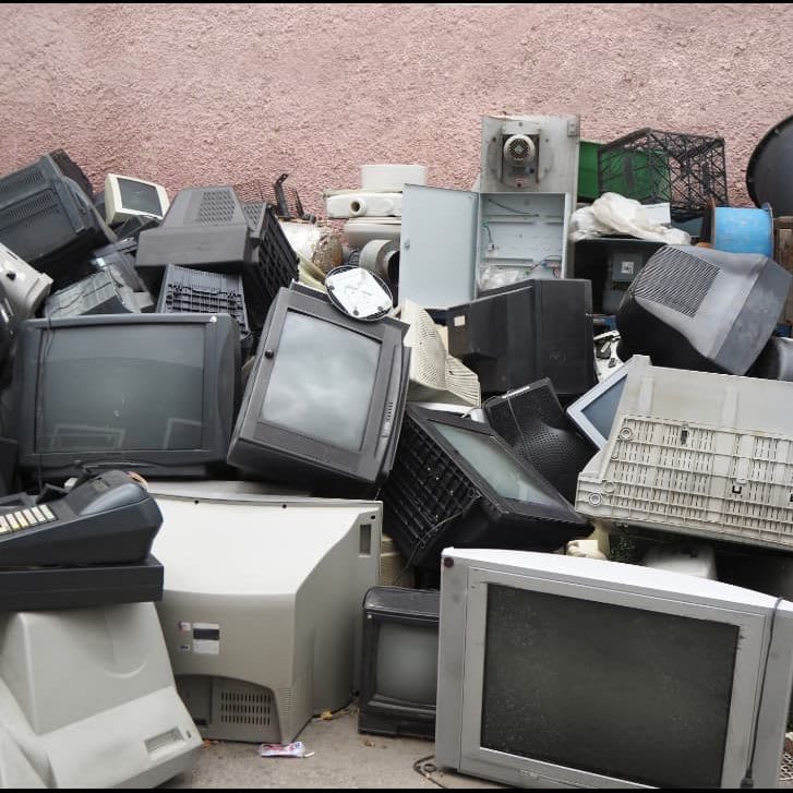 A pile of discarded CRT monitors, televisions and printers awaiting e-waste recycling