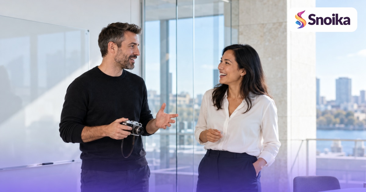 Two people in their forties in a glass-walled meeting room with a whiteboard.