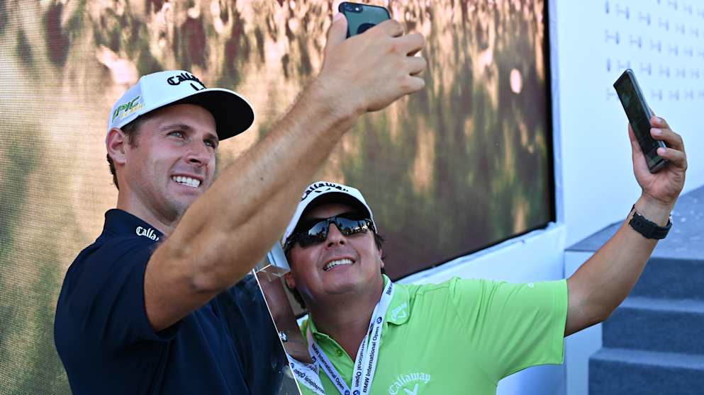 Andrea Pavan and his caddie take selfies after the victory
