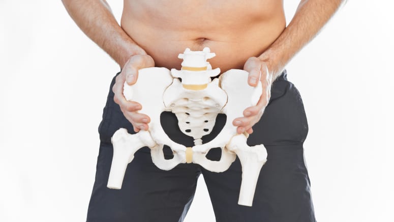 Man holding a skeleton of the pelvis