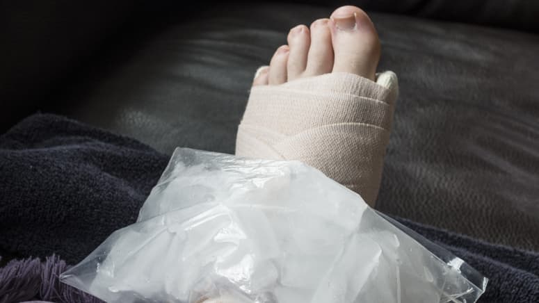 Ice pack placed on a wrapped and elevated ankle