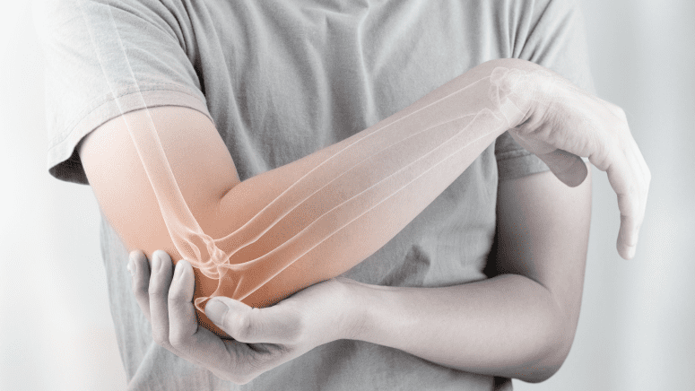 Man grabbing his elbow. The elbow is highlighted in red to indicate pain.