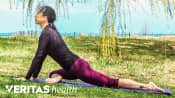 Woman outdoors doing a buttocks stretch.