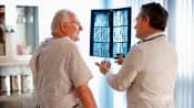 A doctor reviewing an xray of a patient spine with the patient