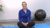 Woman sitting on the floor talking to the camera.