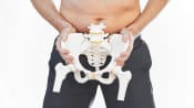 Man holding a skeleton of the pelvis