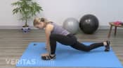 Profile view of woman doing a spiderman stretch.