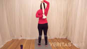Woman pulling a towel behind her back with her right hand above her head, and her left hand at her lower back
