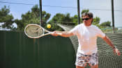 Man hitting a tennis ball on his forehand side.