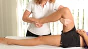 Physical therapist manipulating a patient's leg/thigh
