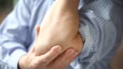 Man grabbing elbow in pain.