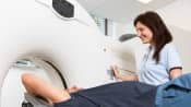 Technician administering MRI for a patient lying supine.