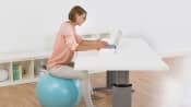 Woman sitting on an exercise ball at her desk.