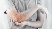 Man grabbing his elbow. The elbow is highlighted in red to indicate pain.