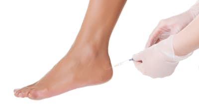 Patient receiving an injection in the achilles heel