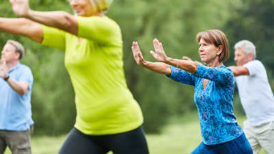 Senior group at the park doing tai chi.