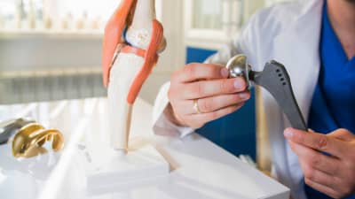 Doctor examining hip implant hardware.