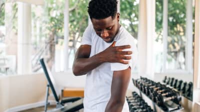 Man grabbing shoulder in pain.