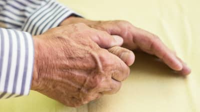 A man rubbing his hands as if in pain
