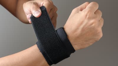 Hand wrapped in a wrist brace.