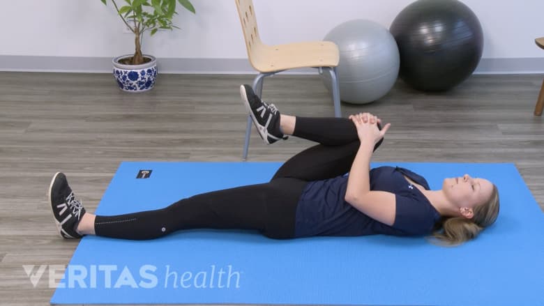 Therapist performing the single knee to chest stretch.