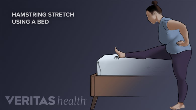 Persona haciendo un estiramiento de isquiotibiales en la cama.