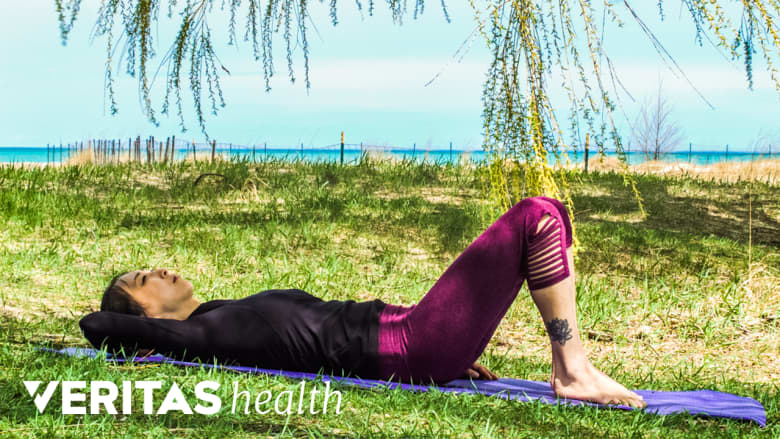 Woman lying prone outdoors doing the pelvic tilt.