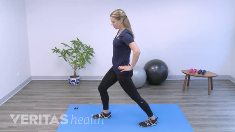 Therapist performing standing lunge exercise.