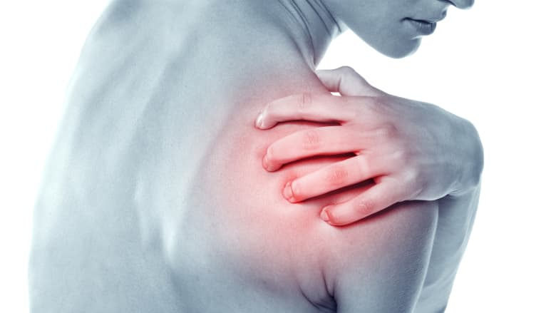 Woman grabbing their shoulder in pain.