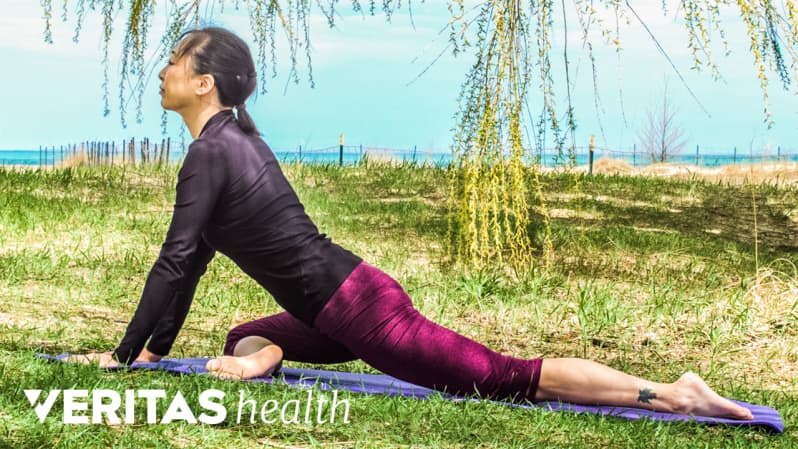 Woman outdoors doing a buttocks stretch.