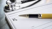 Table with stethoscope, pen, and prescription paper