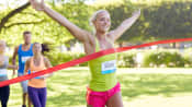 Woman crossing the finish line happily.