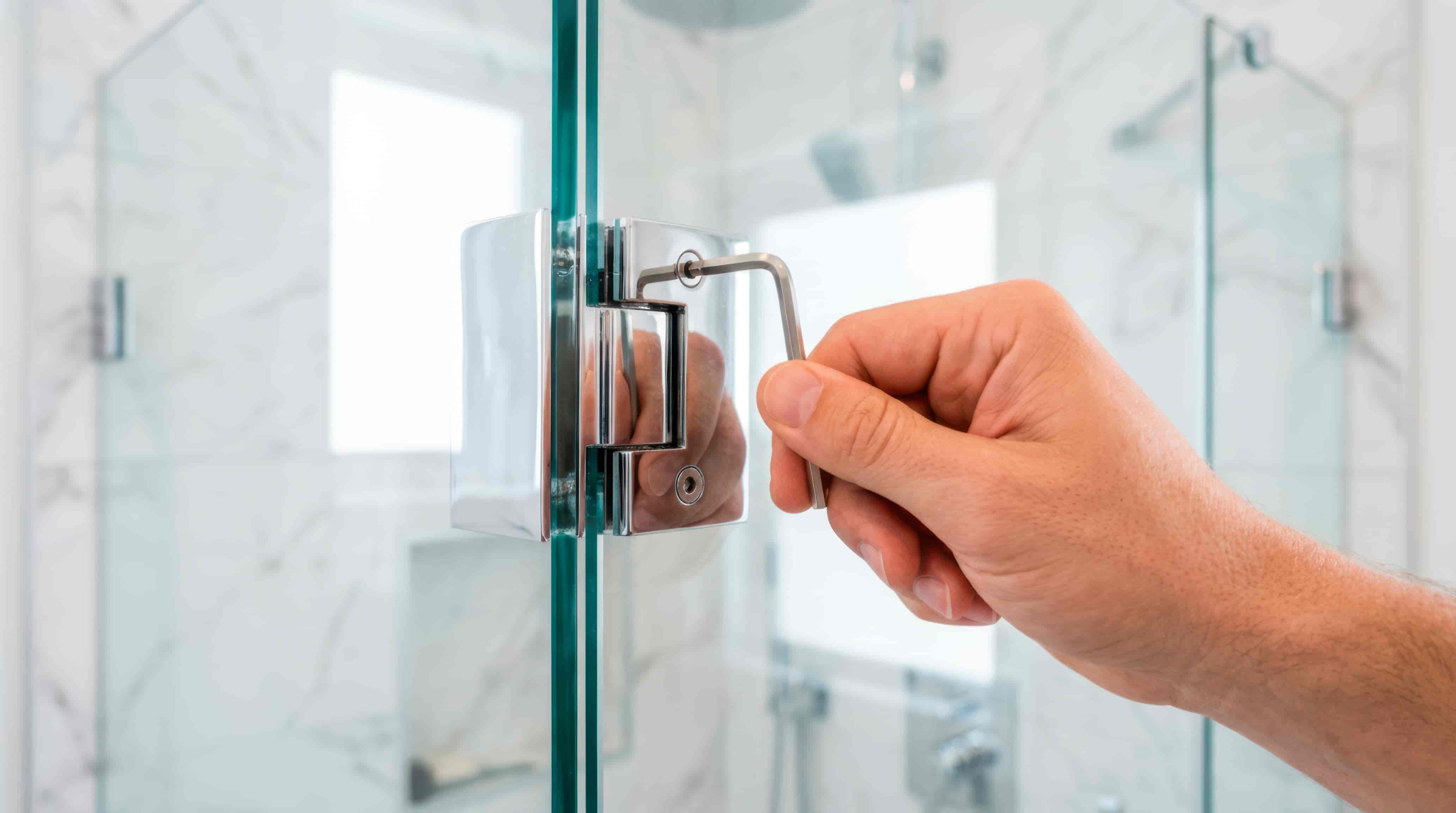 Technician completing a frameless glass shower door installation in a Tampa bathroom for Henderson's Glass & Mirror