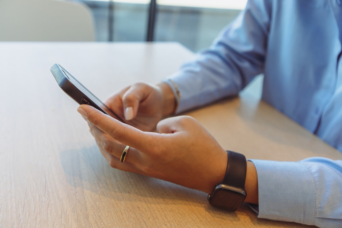 Business owner responding to web enquiries via SMS on mobile phone