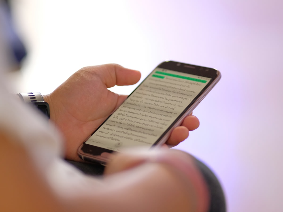 Person checking text message on mobile phone showing high engagement with SMS follow-ups
