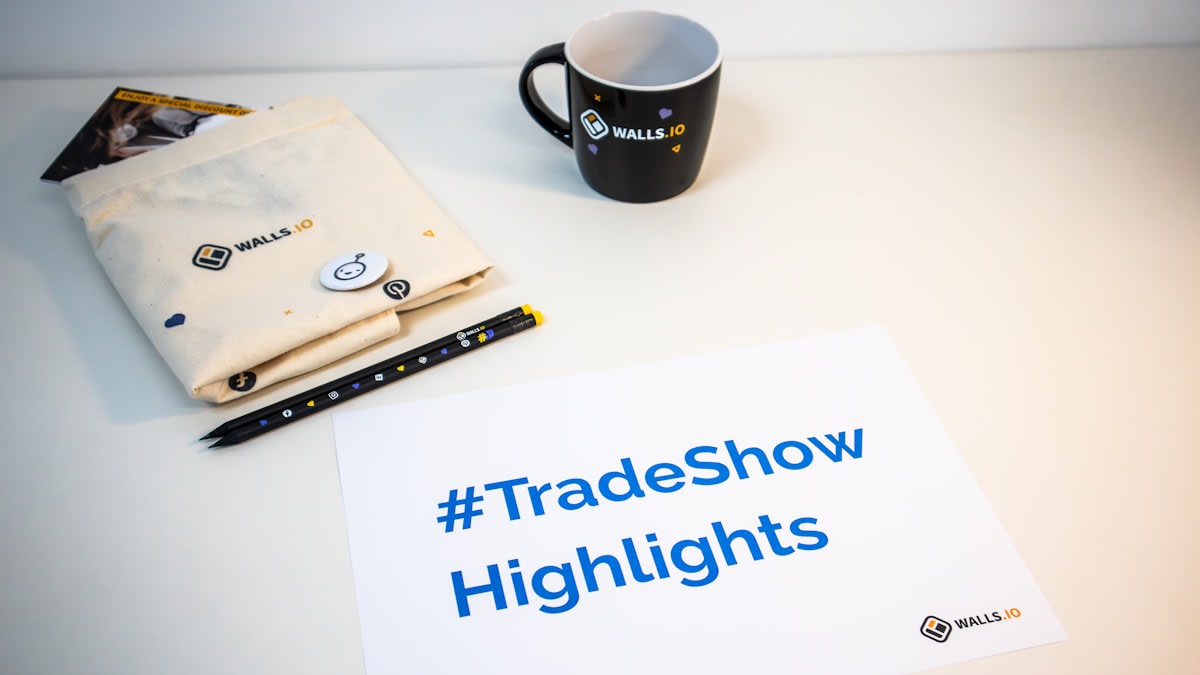 Business professionals networking at a trade show with exhibition stands and lead capture materials