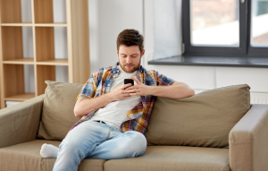 man wearing flannel on his phone to illustrate using venmo for rent