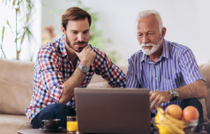 rentredi vs buildium header image: a mid-age man and an older man looking thoughtfully at a laptop