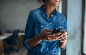 rentredi reviews header image: woman with denim shirt on holding phone and staring thoughtfully out windo