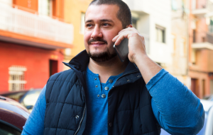 landlord reference image: man wearing blue shirt and vest talking on phone