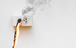holiday electrical accidents: cord plugged into socket on fire