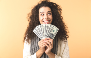 report rent payments blog post: woman smiling while holding fanned out dollar bills