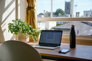 working from home set up: desk, laptop, plan, water bottle, phone
